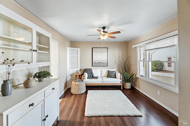 sitting room featuring baseboards, a ceiling fan, and dark wood-style floors
