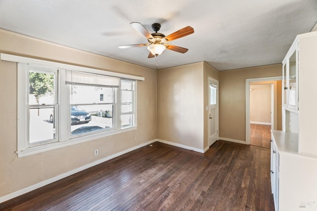 empty room featuring dark wood-type flooring and ceiling fan