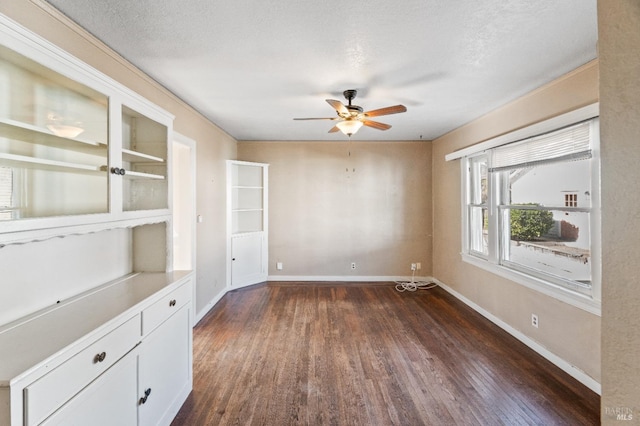 empty room featuring dark hardwood / wood-style floors, a textured ceiling, and ceiling fan