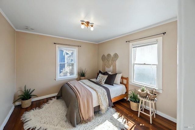 bedroom with crown molding, wood finished floors, and baseboards