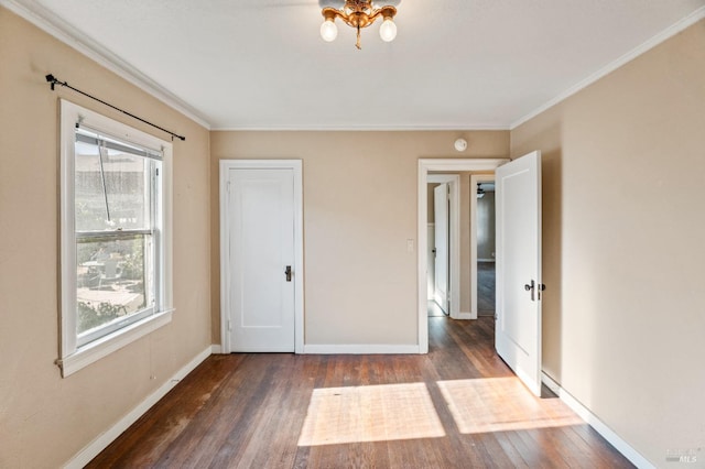 unfurnished bedroom with crown molding and dark wood-type flooring