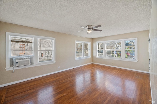 unfurnished room featuring cooling unit, hardwood / wood-style flooring, a wealth of natural light, and ceiling fan