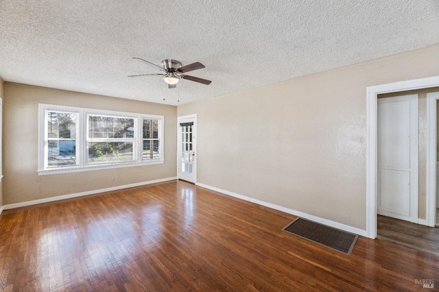 empty room with dark wood-type flooring, ceiling fan, and a textured ceiling