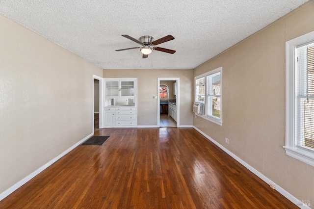 interior space featuring dark wood-type flooring, a healthy amount of sunlight, and a textured ceiling