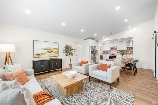 living room with vaulted ceiling and light hardwood / wood-style floors