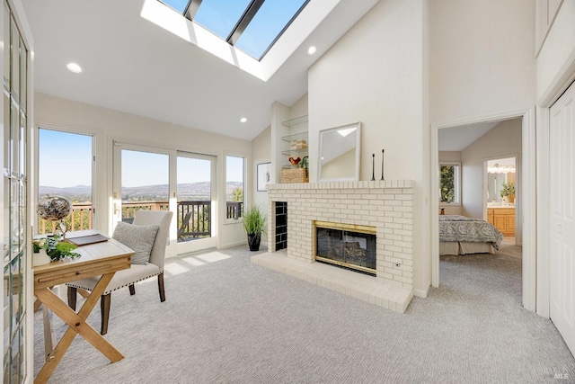 carpeted living room featuring high vaulted ceiling, a brick fireplace, a mountain view, and a wealth of natural light