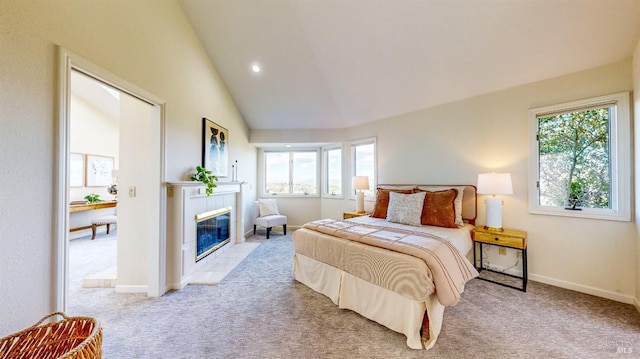 carpeted bedroom with high vaulted ceiling, a tiled fireplace, and multiple windows