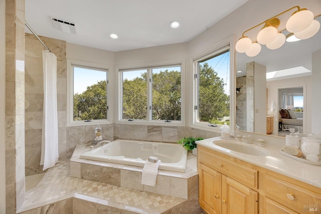 bathroom with vanity, separate shower and tub, and plenty of natural light