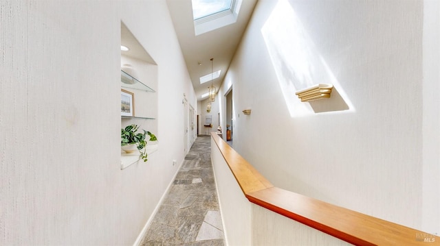 hall featuring lofted ceiling with skylight