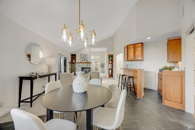 dining room featuring a notable chandelier and high vaulted ceiling