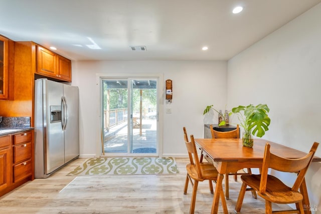 kitchen with light hardwood / wood-style floors and stainless steel refrigerator with ice dispenser