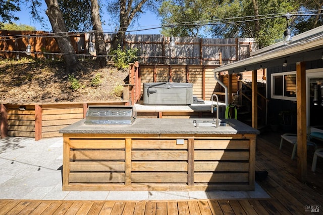 wooden terrace with a hot tub and sink