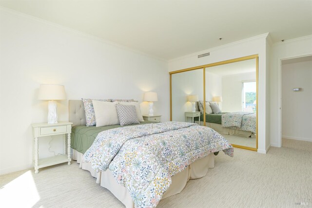 bedroom with crown molding, light colored carpet, and a closet