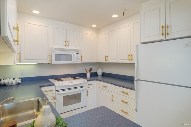 kitchen with white appliances, sink, and white cabinets