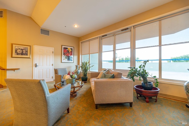 carpeted living room with lofted ceiling, a wealth of natural light, and a water view