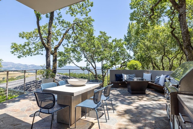 view of patio featuring a mountain view, outdoor lounge area, and a grill