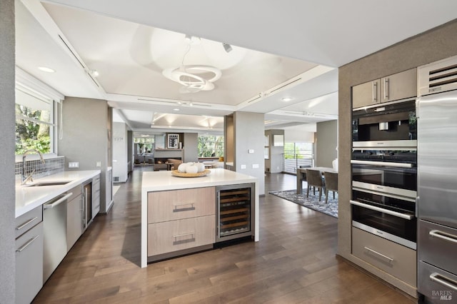 kitchen featuring beverage cooler, a kitchen island, a wealth of natural light, and stainless steel appliances