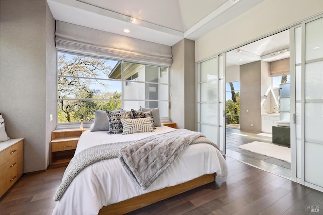 bedroom with dark wood-type flooring and connected bathroom