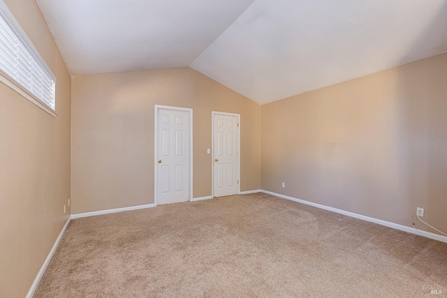 unfurnished bedroom featuring vaulted ceiling and carpet floors