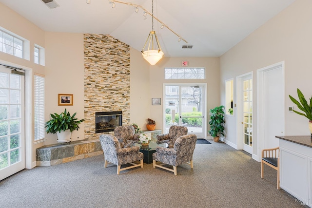 carpeted living room featuring a fireplace and high vaulted ceiling