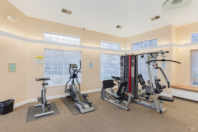 gym with a high ceiling and carpet flooring