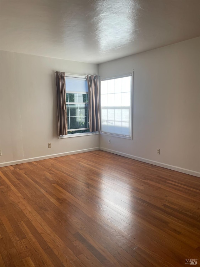 unfurnished room with dark hardwood / wood-style floors