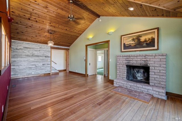 unfurnished living room with high vaulted ceiling, wooden ceiling, a fireplace, wood finished floors, and baseboards