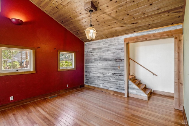 unfurnished room with lofted ceiling, wood ceiling, plenty of natural light, and light wood finished floors