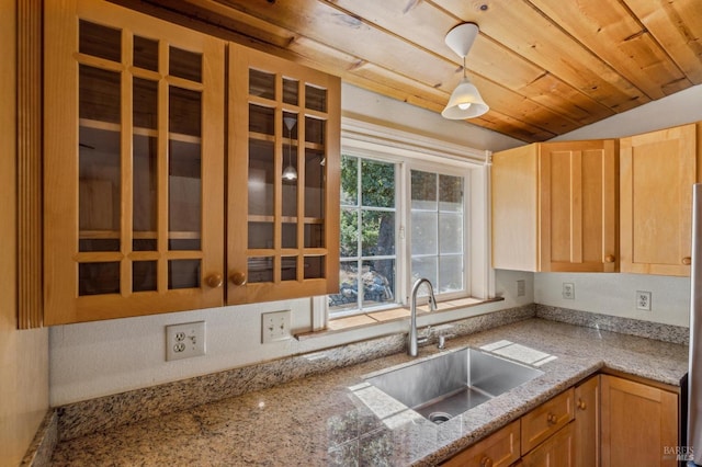 kitchen with lofted ceiling, hanging light fixtures, glass insert cabinets, wood ceiling, and a sink