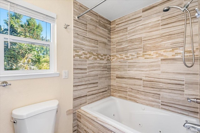 bathroom with tiled shower / bath combo and toilet