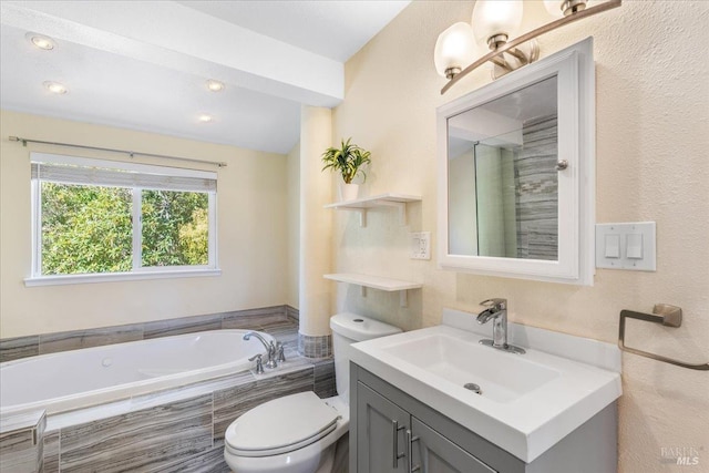 bathroom with vanity, toilet, and tiled bath