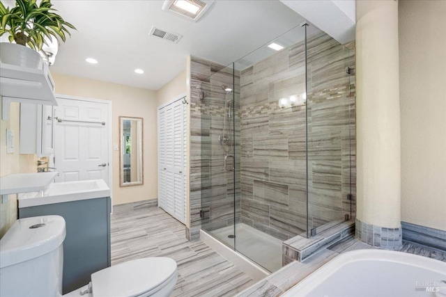 full bathroom featuring shower with separate bathtub, vanity, and toilet