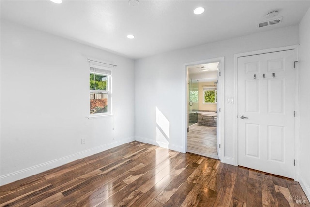 interior space with ensuite bathroom and dark wood-type flooring