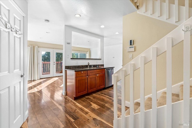 bar with french doors, dark hardwood / wood-style floors, stainless steel dishwasher, and sink