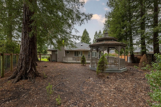 back of property with a gazebo and a wooden deck