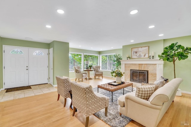 living room with light wood-type flooring and a high end fireplace