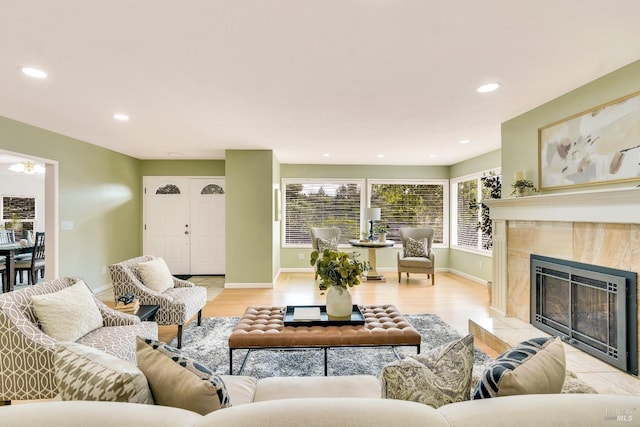 living room with light wood-type flooring and a tile fireplace