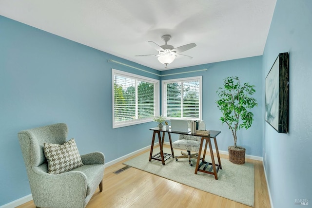 home office featuring wood-type flooring and ceiling fan