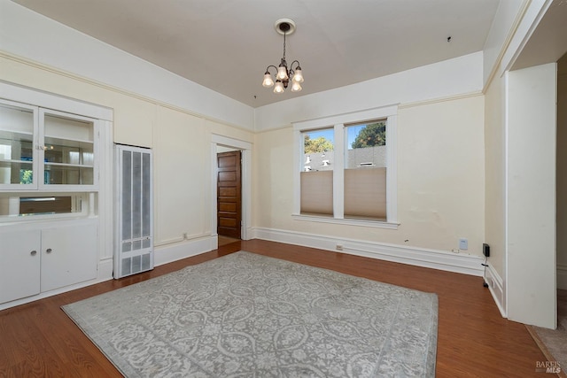 spare room with lofted ceiling, hardwood / wood-style floors, and a notable chandelier