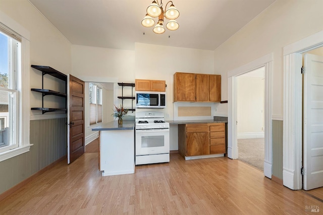 kitchen featuring an inviting chandelier, white gas stove, and light wood-type flooring