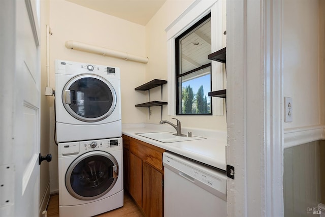 washroom with stacked washing maching and dryer and sink