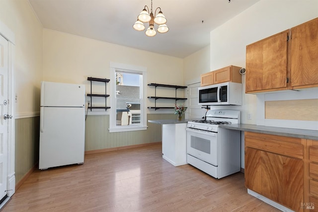 kitchen with pendant lighting, white appliances, a notable chandelier, and light wood-type flooring