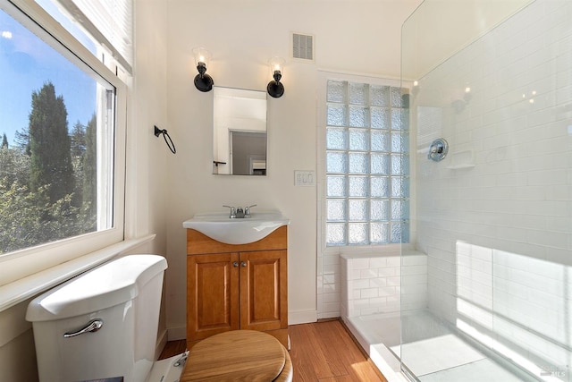 bathroom featuring tiled shower, vanity, and hardwood / wood-style floors