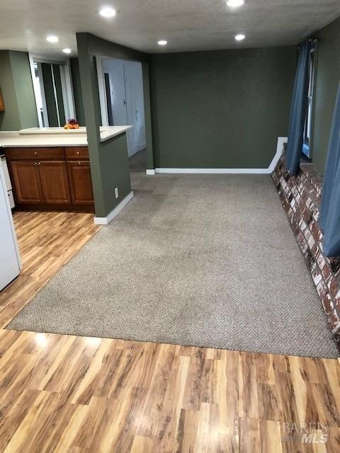 unfurnished living room with baseboards, recessed lighting, and light wood finished floors