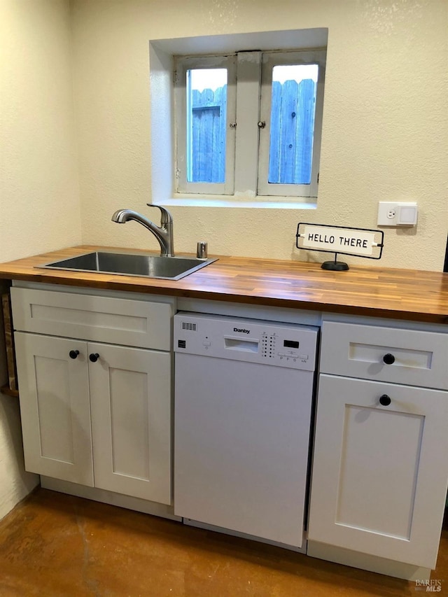 kitchen with sink, wooden counters, and white dishwasher