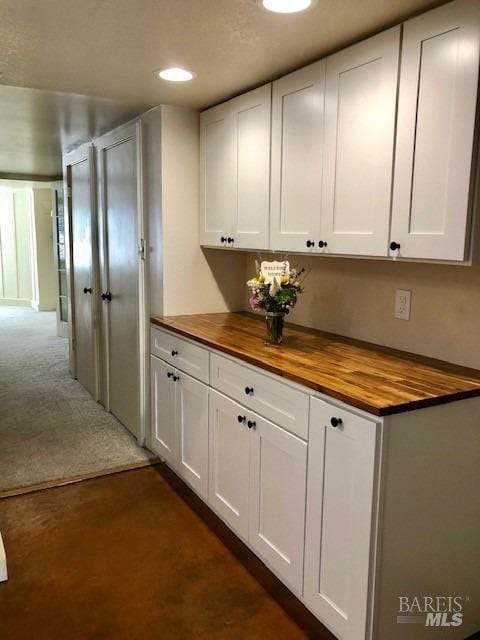 kitchen with wood counters and white cabinets