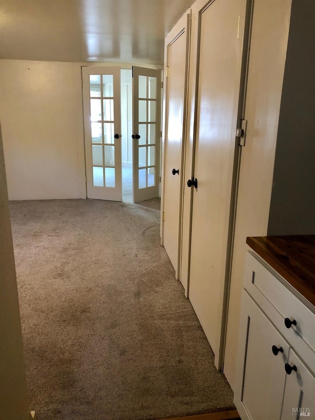 interior space with french doors and light colored carpet