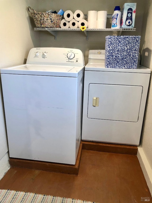 laundry area with dark hardwood / wood-style floors and washing machine and clothes dryer