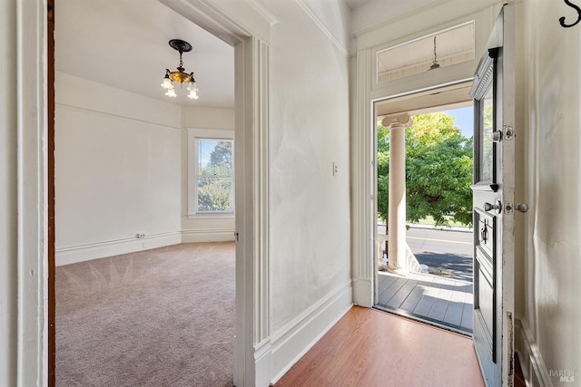 foyer featuring an inviting chandelier and carpet flooring