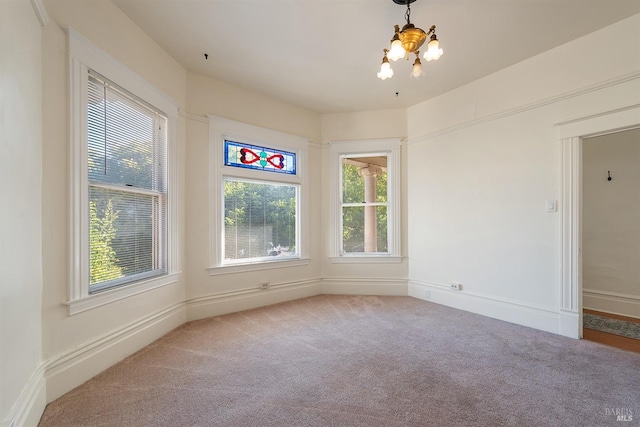 spare room featuring an inviting chandelier and carpet